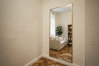 Grand miroir rectangulaire à cadre en laiton dans un studio parisien agrandissant visuellement l'espace