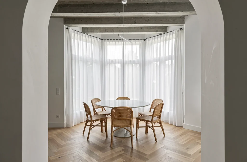 Salle à manger moderne avec rideaux en voile blanc tamisants transformant l'ambiance d'une pièce à vivre contemporaine